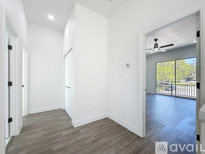 A spacious room with a sliding glass door leading to a balcony.