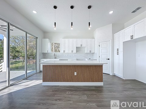 A modern kitchen with white cabinets and a wooden island.