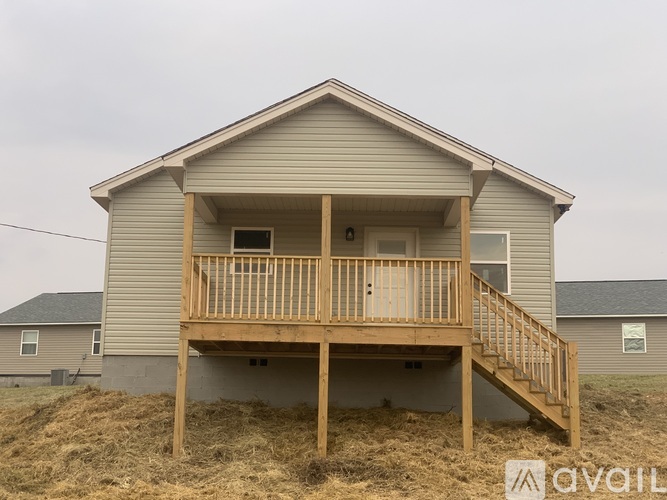 A house with a deck and stairs leading to the entrance.