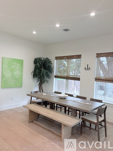 A dining room with a wooden table and chairs.