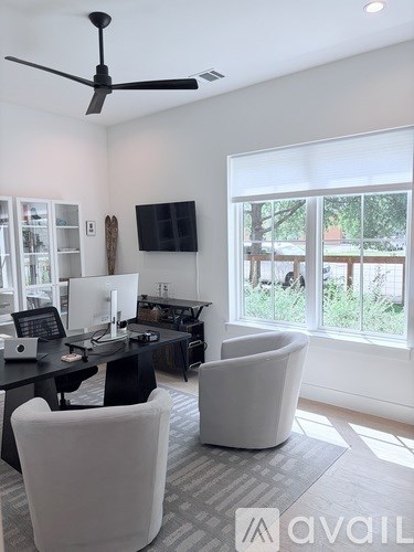 A living room with a black table and white chairs.