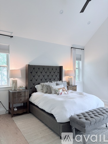 A bedroom with a large bed and a wooden nightstand.
