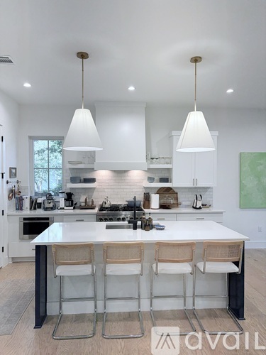 A modern kitchen with white cabinets and a large island.