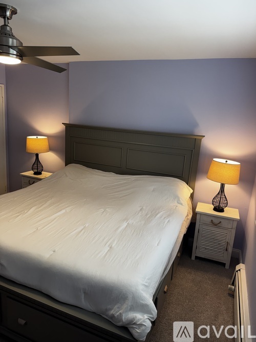 A bedroom with a bed, nightstand, and two lamps.
