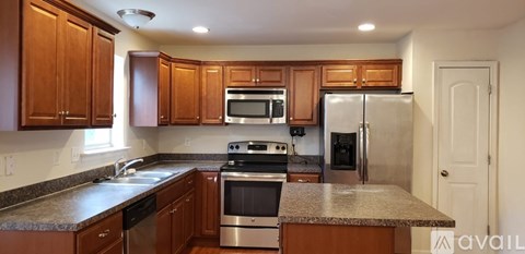 A kitchen with wooden cabinets and granite countertops.