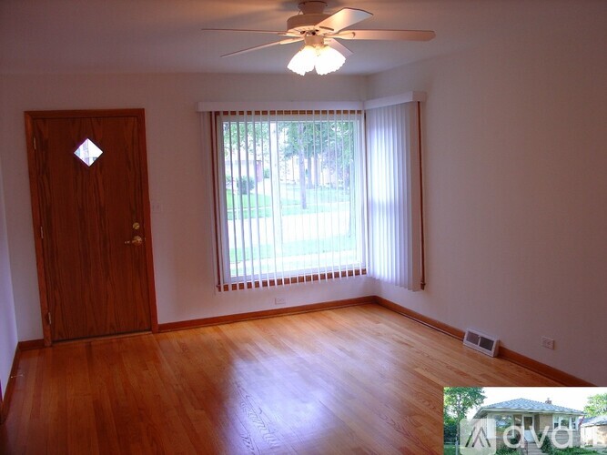 A room with a ceiling fan and a door.