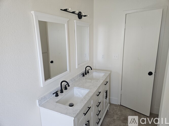 A bathroom with a sink, mirror, and cabinet.