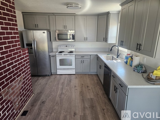 A kitchen with a refrigerator, oven, and microwave.