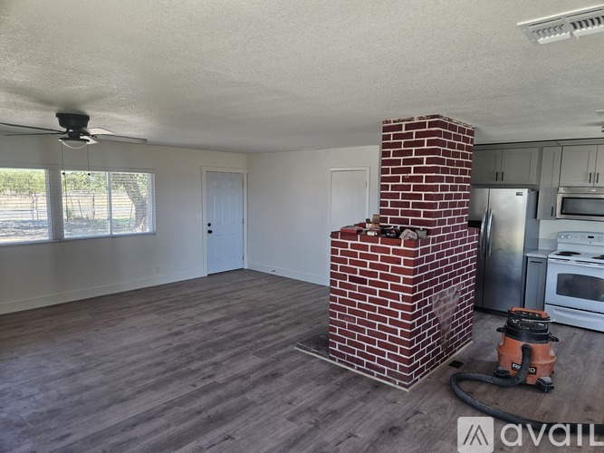 A room with a brick chimney and wooden flooring.