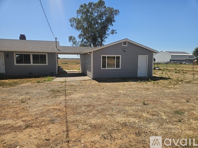 Two houses are situated in a dry, grassy field.