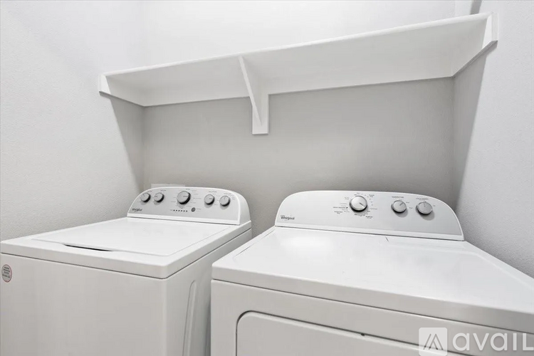 Two white front loading washing machines in a laundry room.