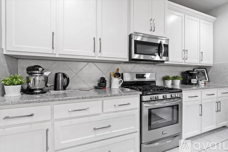 A kitchen with white cabinets and appliances.