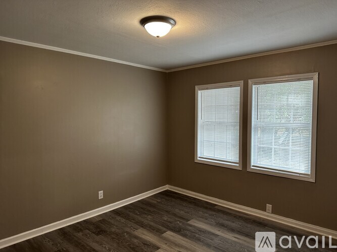 A room with brown walls and a window with blinds.