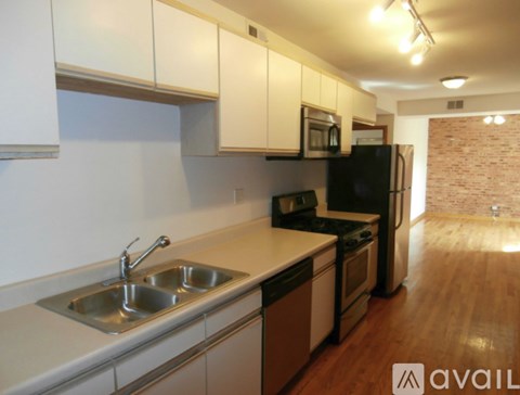 A kitchen with a sink, stove, and refrigerator.