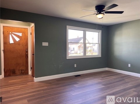 A room with a ceiling fan and a window.