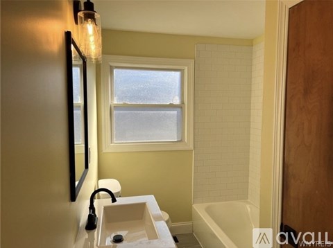 A bathroom with a white sink and a window.