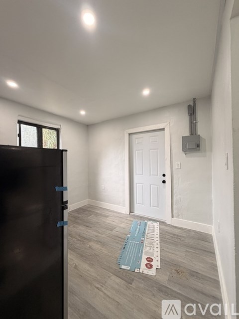 A room with a door, a window, and a mat on the floor.