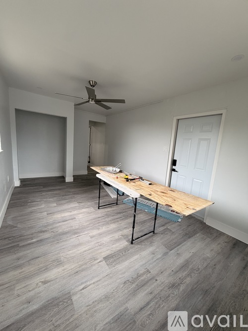 A room with a table and a fan on the ceiling.