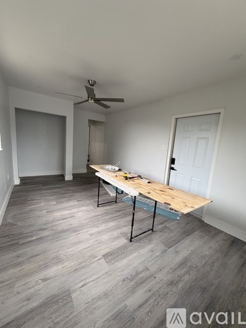A room with a table and a fan on the ceiling.