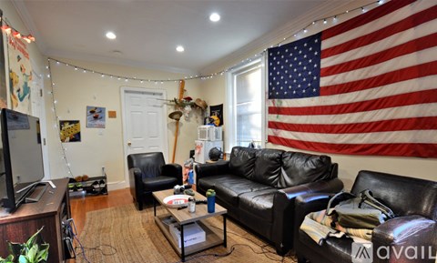 A living room with a large American flag on the wall.