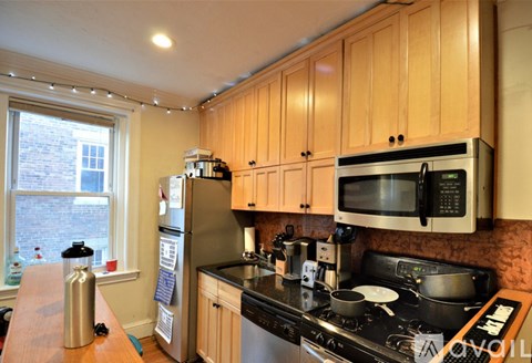 A kitchen with wooden cabinets and a black stove top.