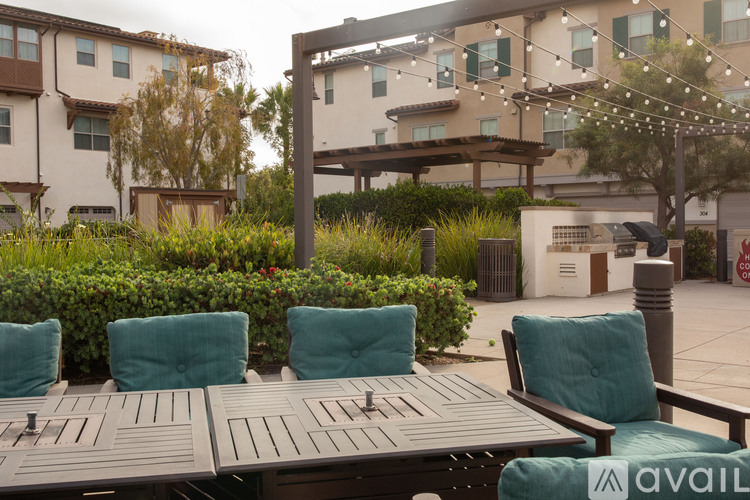 A patio with chairs and tables is set up in front of a building.