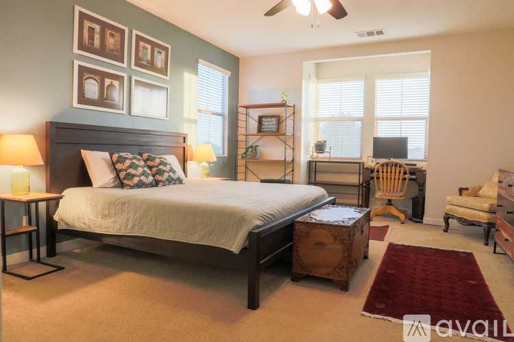 A bedroom with a large bed and a ceiling fan.
