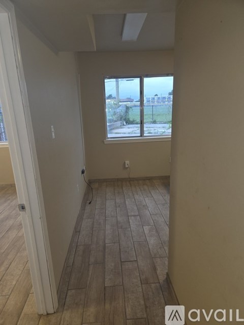 A room with a window and wooden flooring.