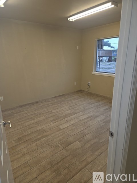 A room with wooden flooring and a window.