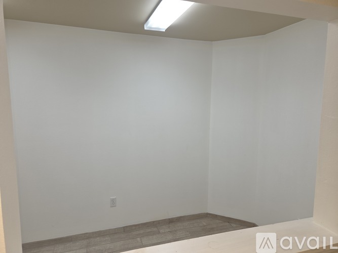 A room with a white wall and a light on the ceiling.