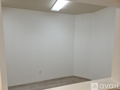A room with a white wall and a light on the ceiling.
