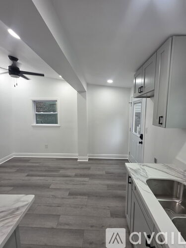 A kitchen with a fan on the ceiling and a window.