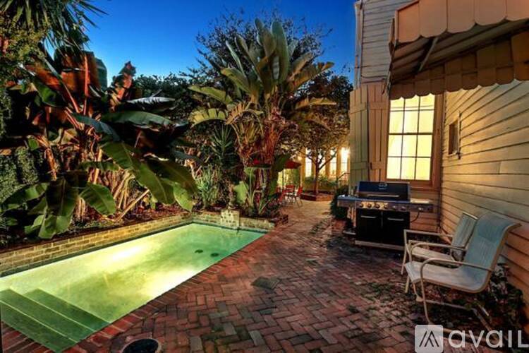 A backyard with a pool and patio furniture.