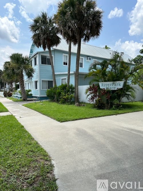 A blue house with a sign that says River Park in front of it.