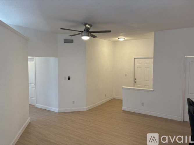 A spacious room with a ceiling fan and light fixture.