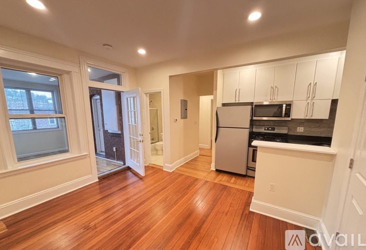 A kitchen with white cabinets and a wooden floor.