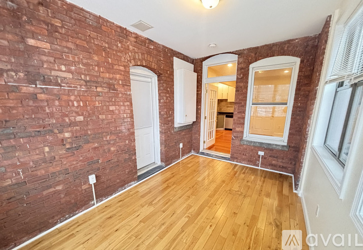 A room with a brick wall and wooden flooring.