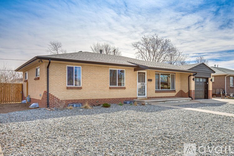A house with a gravel driveway in front.