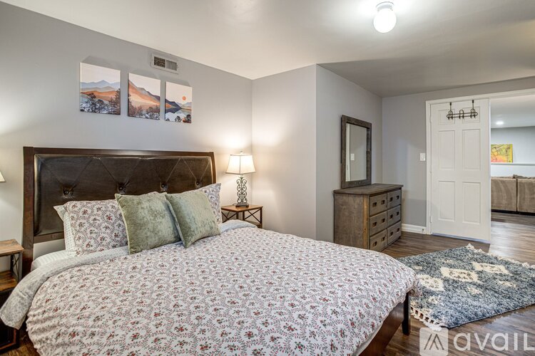 A bedroom with a large bed and a dresser.