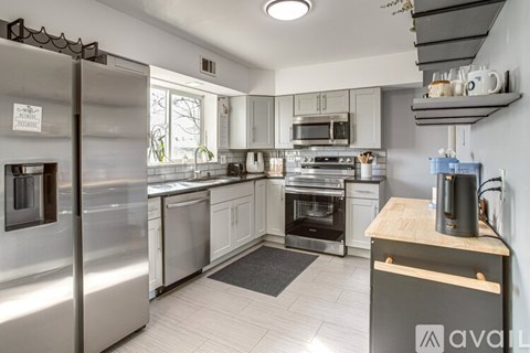A kitchen with a stainless steel refrigerator and a wooden counter.