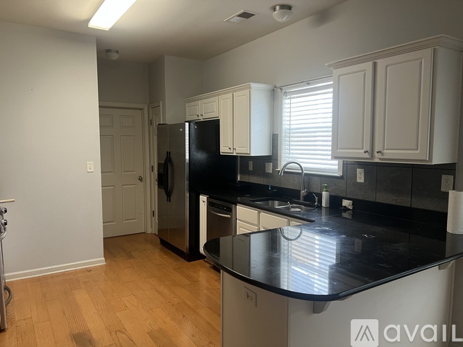 A kitchen with black countertops and white cabinets.