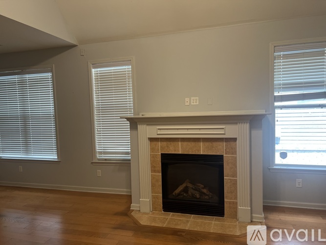 A fireplace in a room with a window on the right.