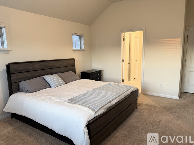 A bedroom with a large bed and a nightstand.