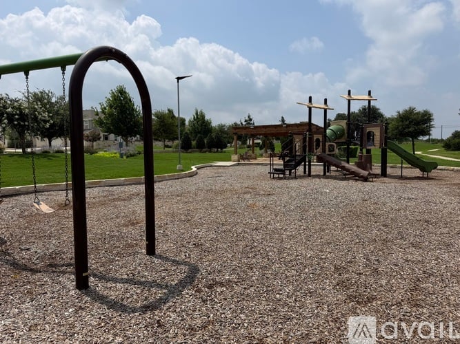 A playground with a swing set and a green slide.