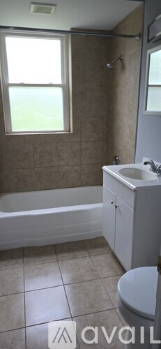A bathroom with a tub, toilet, and sink.