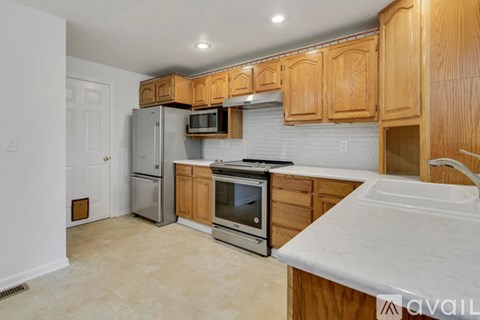 A kitchen with wooden cabinets and a white countertop.