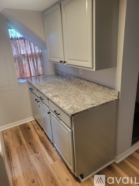 A kitchen with white cabinets and a granite countertop.