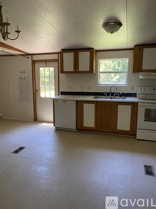 A kitchen with white appliances and wooden cabinets.