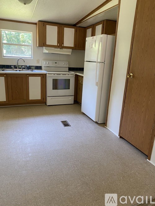 A kitchen with white appliances and wooden cabinets.