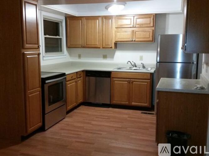 A kitchen with wooden cabinets and a refrigerator.